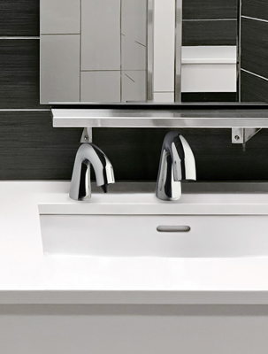 EQ® Series faucets and soap dispensers in a modern restroom with dark tile and white sink deck