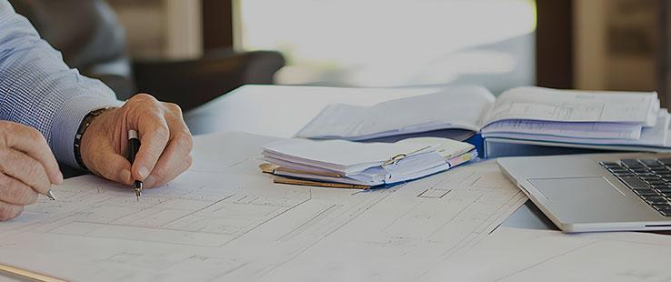 Architect referring to documents to update drawing