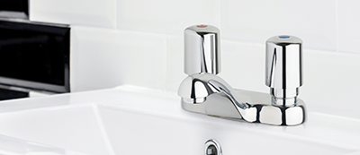 802 Series metering faucet in black-and-white restroom