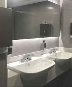 public restroom with two sinks and chrome touchless faucets